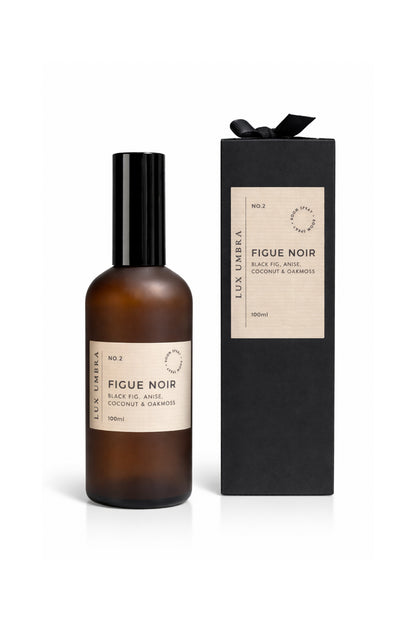 Amber glass bottle and black box with 'Figue Noir' label on a white background