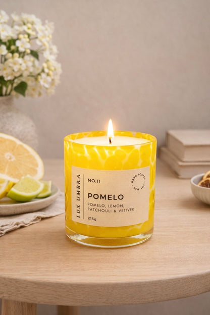 A yellow tortoiseshell candle called Pomelo, sitting on a table
