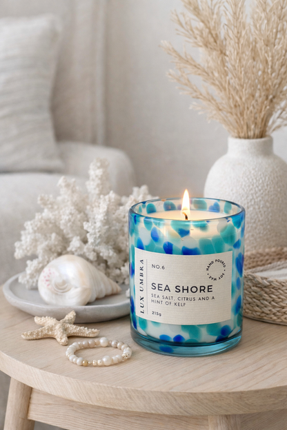 A blue tortoiseshell patterned candle called Sea Shore, sitting on a table