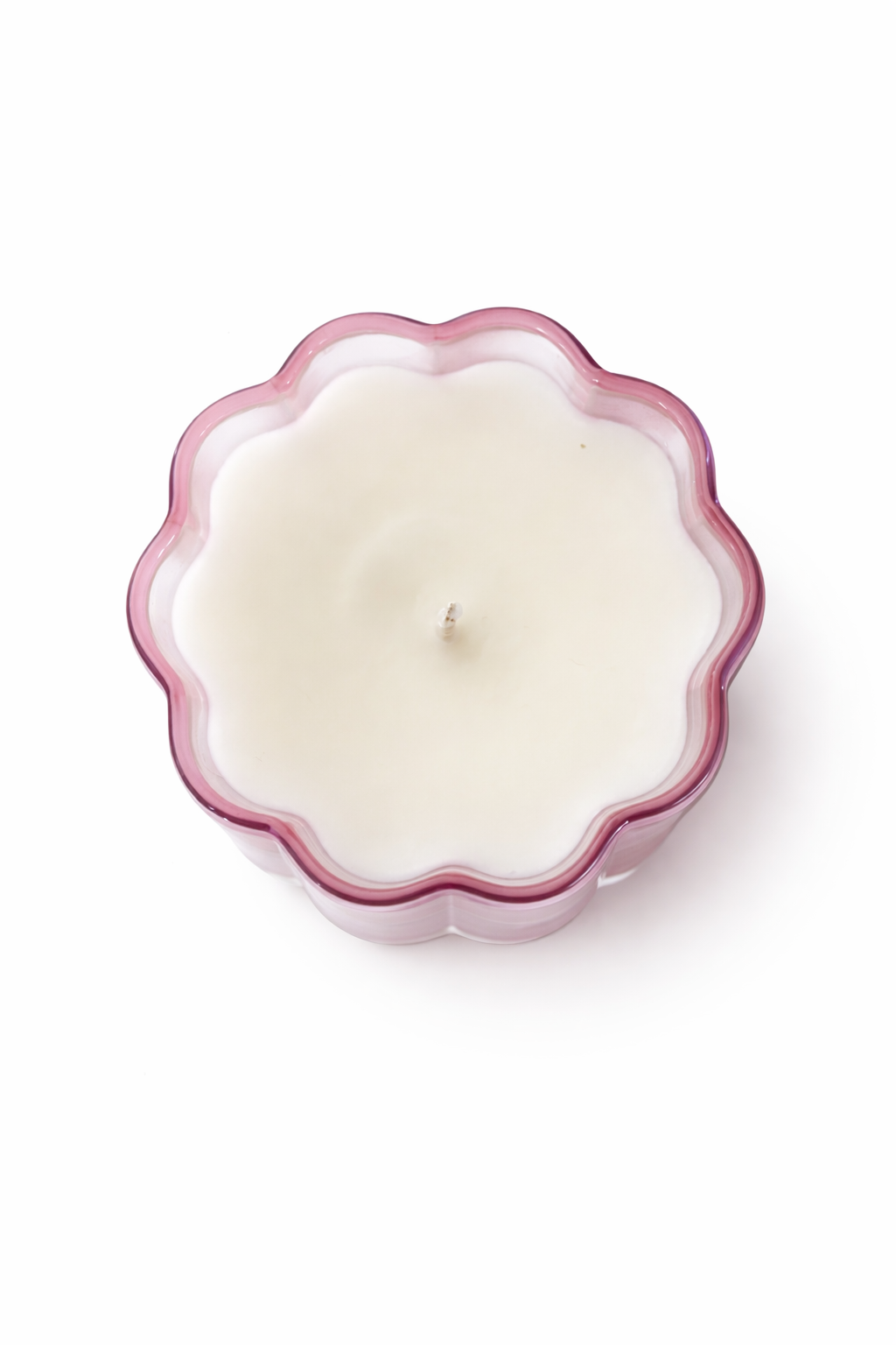 White candle in a decorative pink holder on a white background