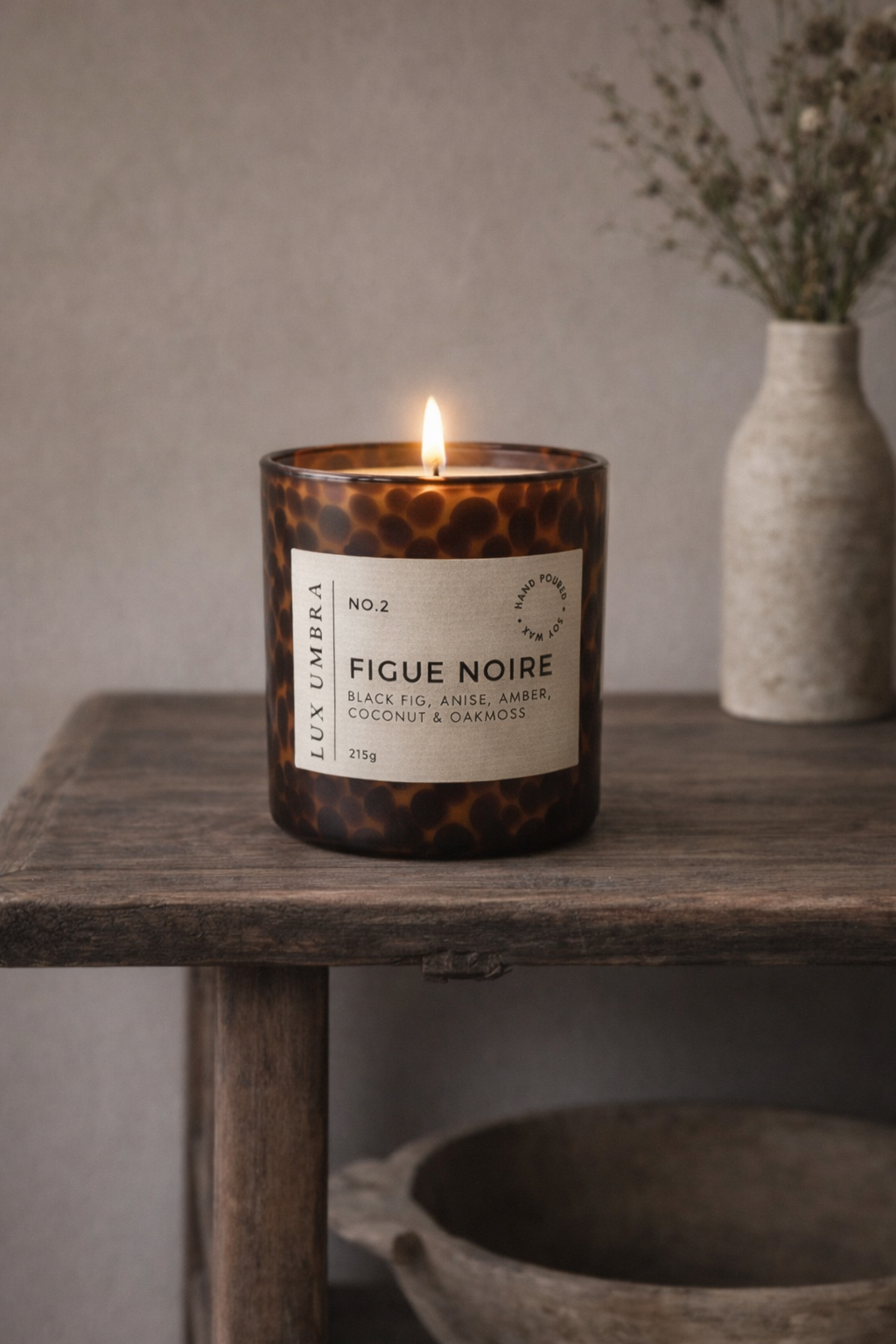 Brown tortoiseshell Candle labeled 'Figue Noire' on a wooden table with a neutral background