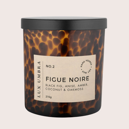 A lux Umbra candle in a brown tortoiseshell glass jar labeled Figue Noire