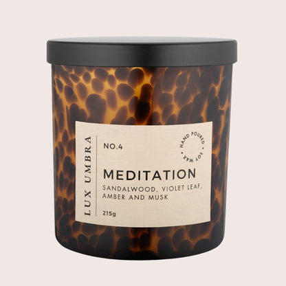 A brown tortoiseshell candle called Meditation by Lux Umbra. On a white background. 