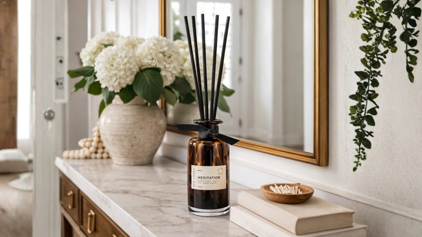 A tortoiseshell diffuser on a table with decorative items including a vase of flowers and a mirror.